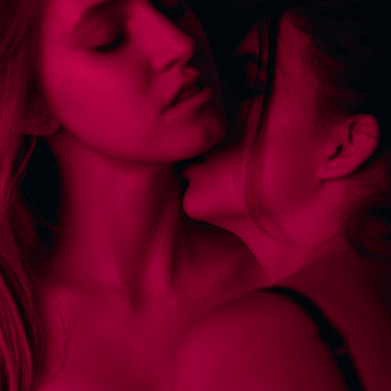 Woman kissing other woman's neck