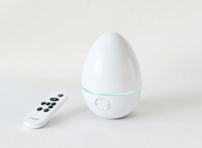 A modern egg vibrator with remote control on a neutral background